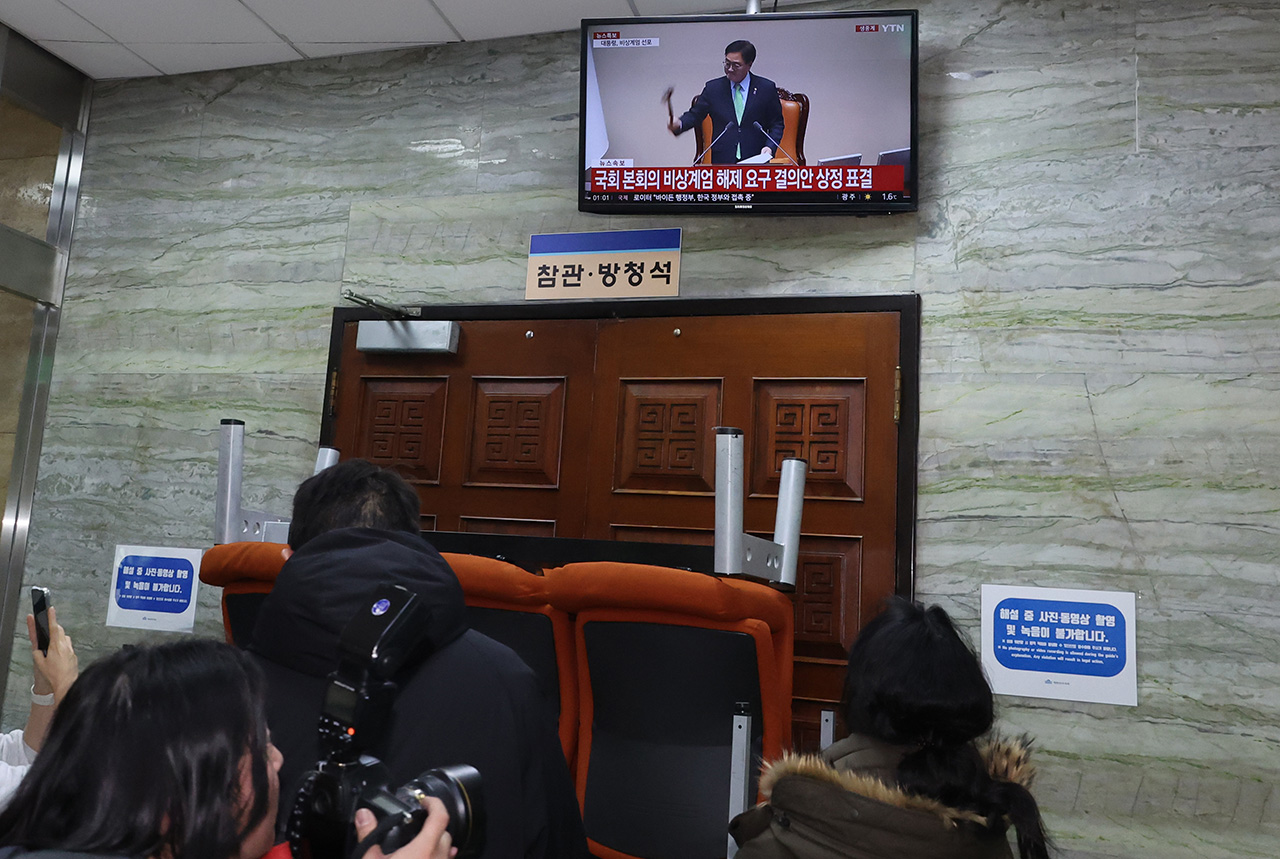 2024년 12월4일 새벽 국회 관계자들이 12·3 비상계엄 해제요구 결의안 가결 모습을 지켜보고 있다. ⓒ연합뉴스